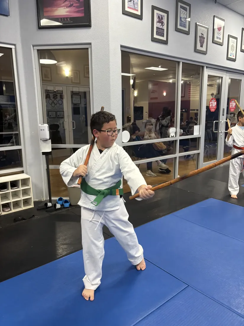 A young green belt practicing a martial arts stance at Fusion Elite in Rocklin